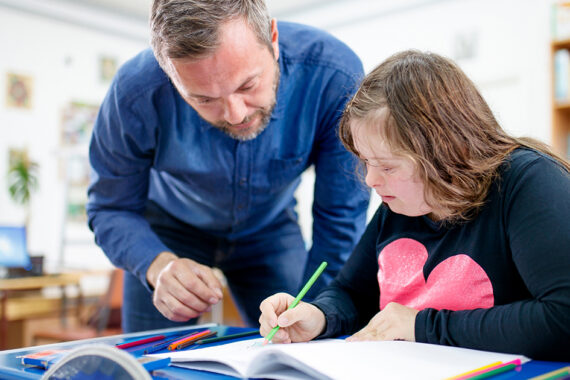 Teenage girl with down syndrome drawing at class