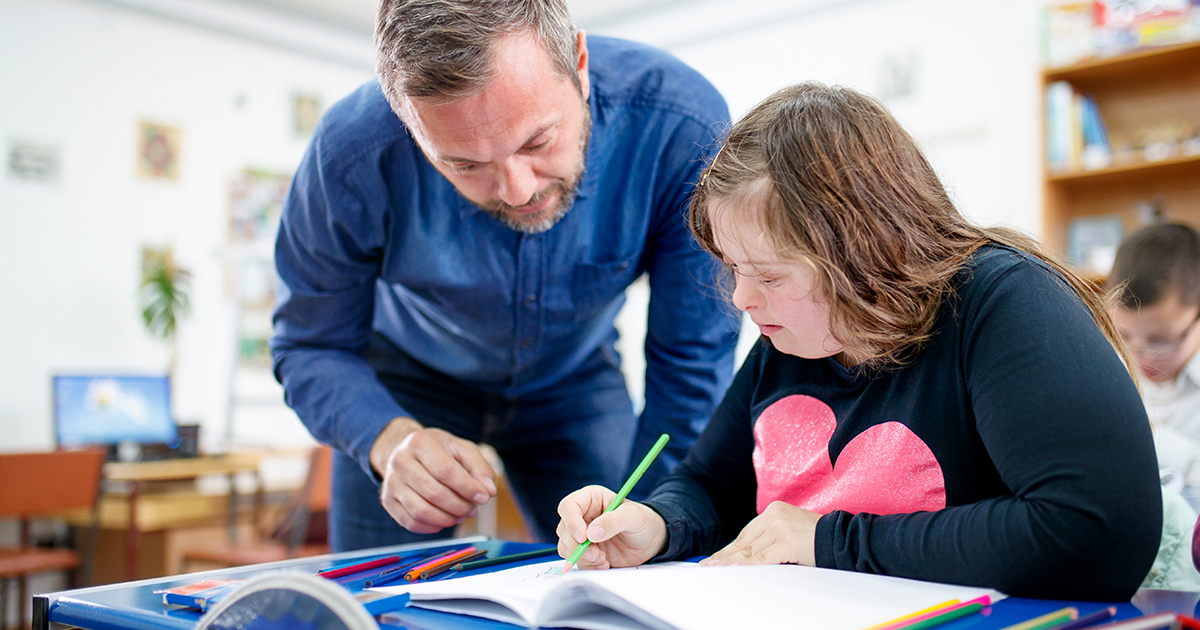 Teenage girl with down syndrome drawing at class