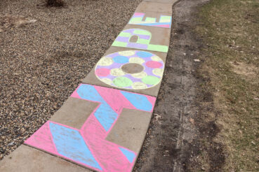 multi-colored chalk lettering on sidewalk that spells Hope