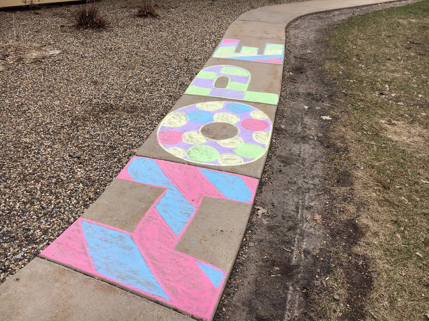 multi-colored chalk lettering on sidewalk that spells Hope