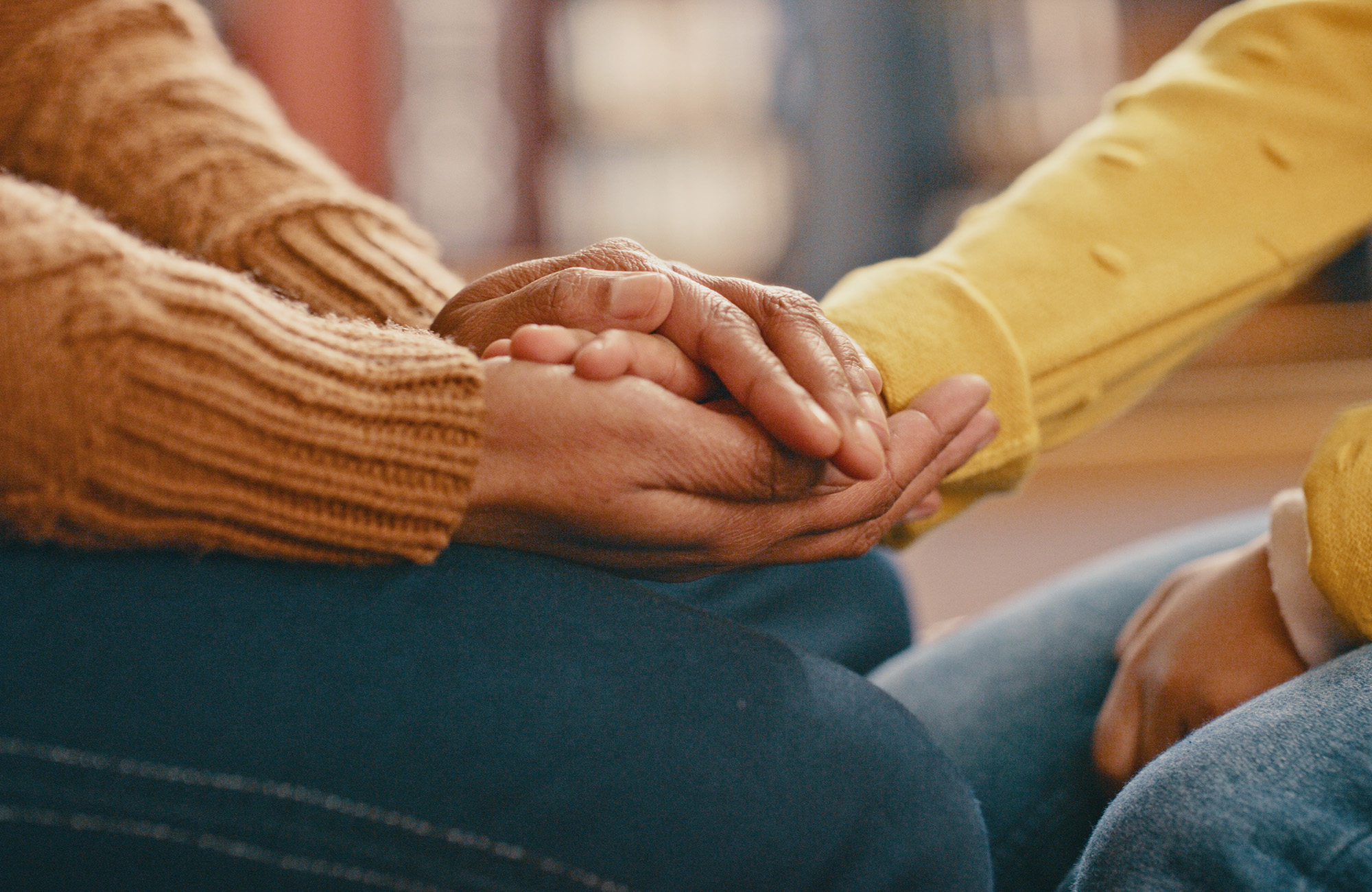 Two people holding hands to share support
