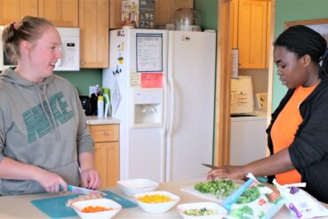 two people prepare food in group home kitchen