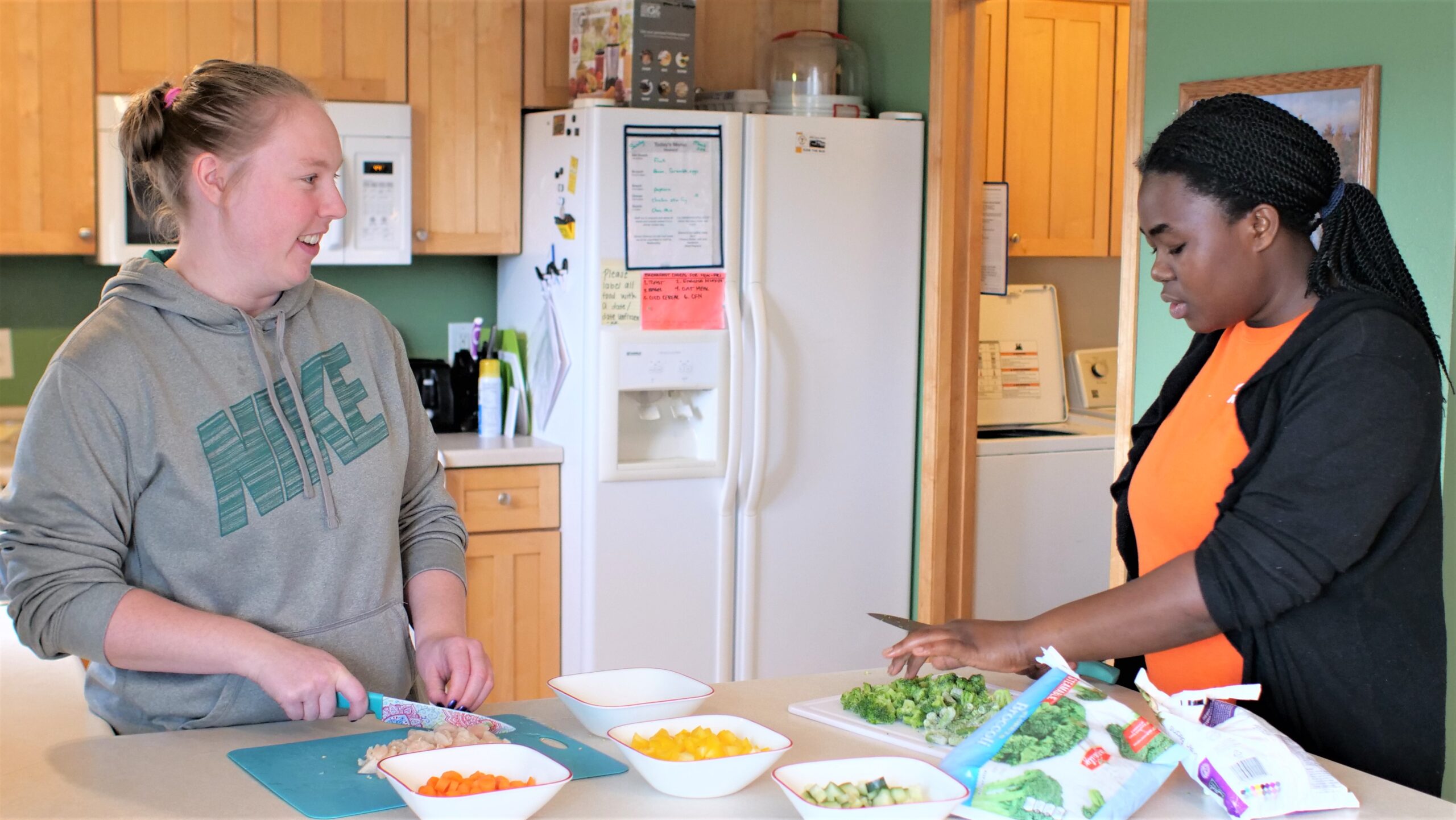 two people prepare food in group home kitchen