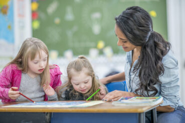 Two children with teacher at school