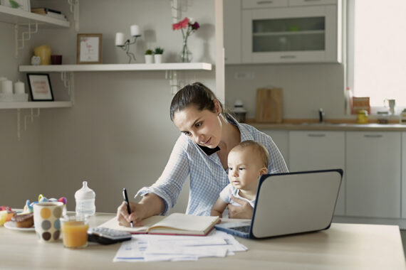 mom and baby working on laptop and on the phone