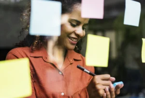 woman writing on post it notes