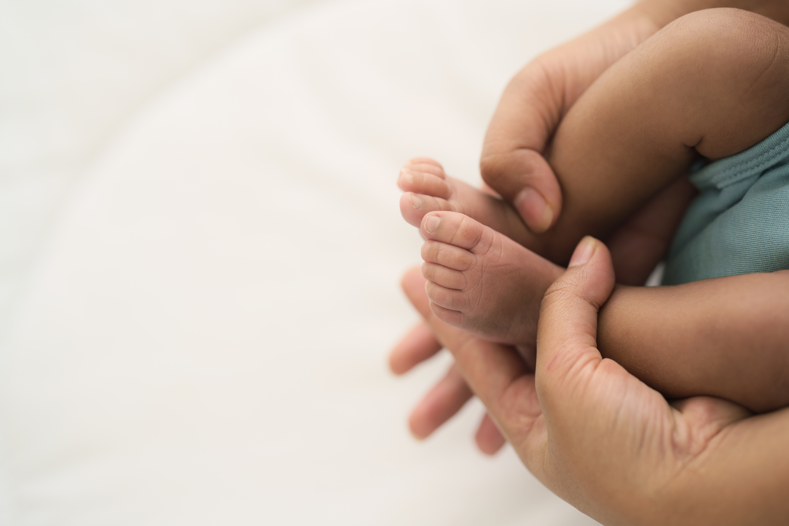 Closeup of parent holding infant feet